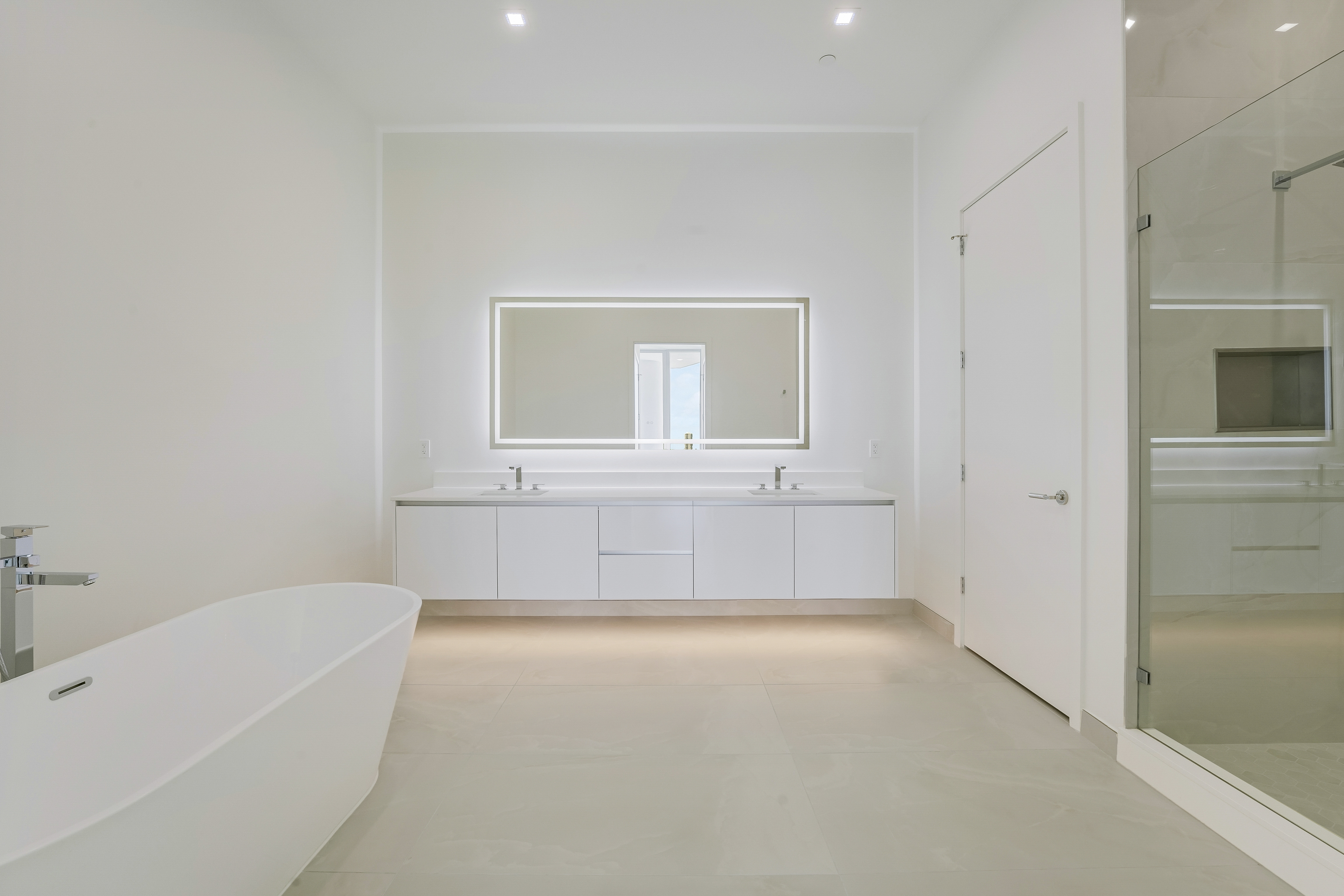 Primary bathroom with freestanding tub, double vanity and glass shower in Residence 612