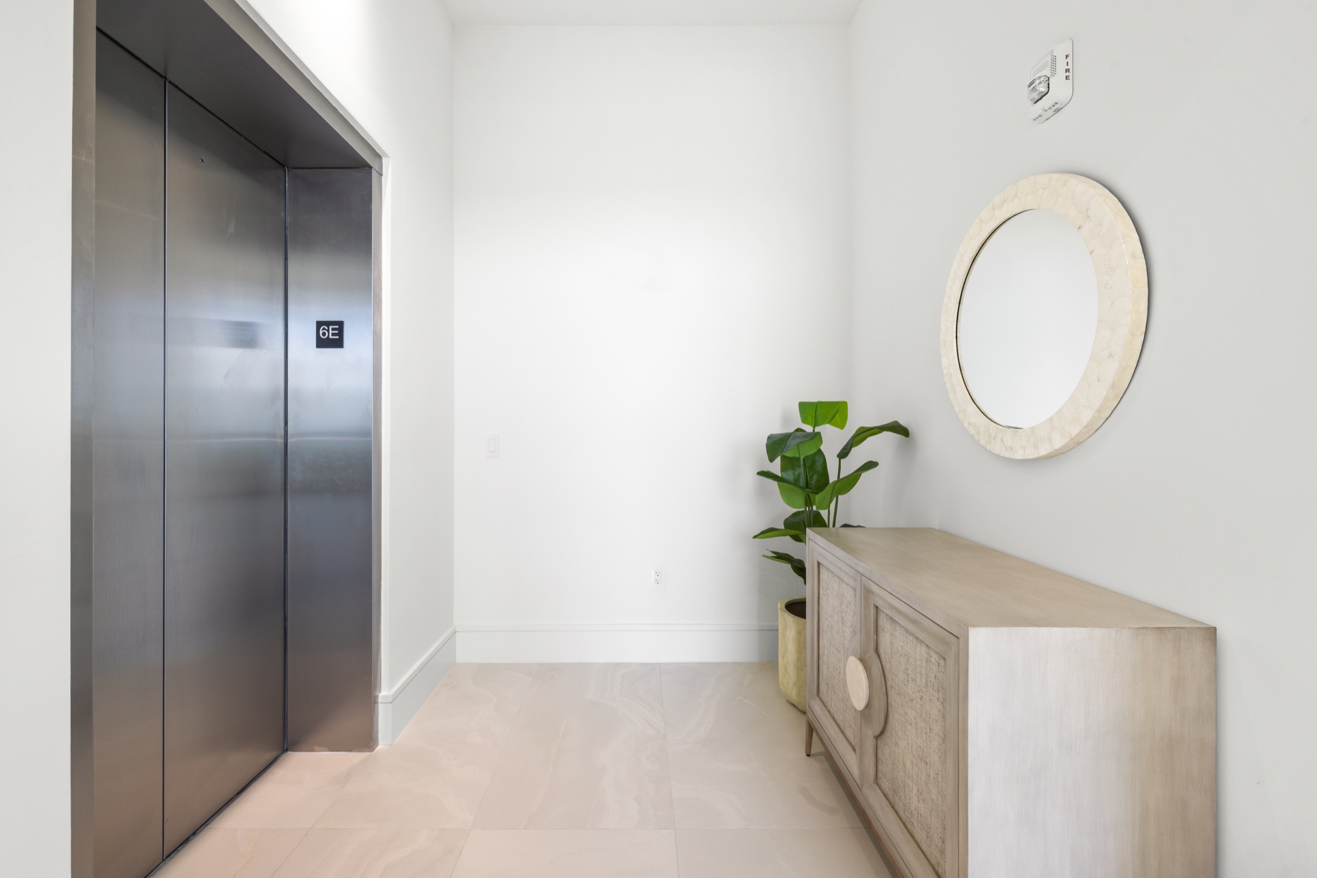Private elevator arrival furnished with a console and mirror at Residence 612
